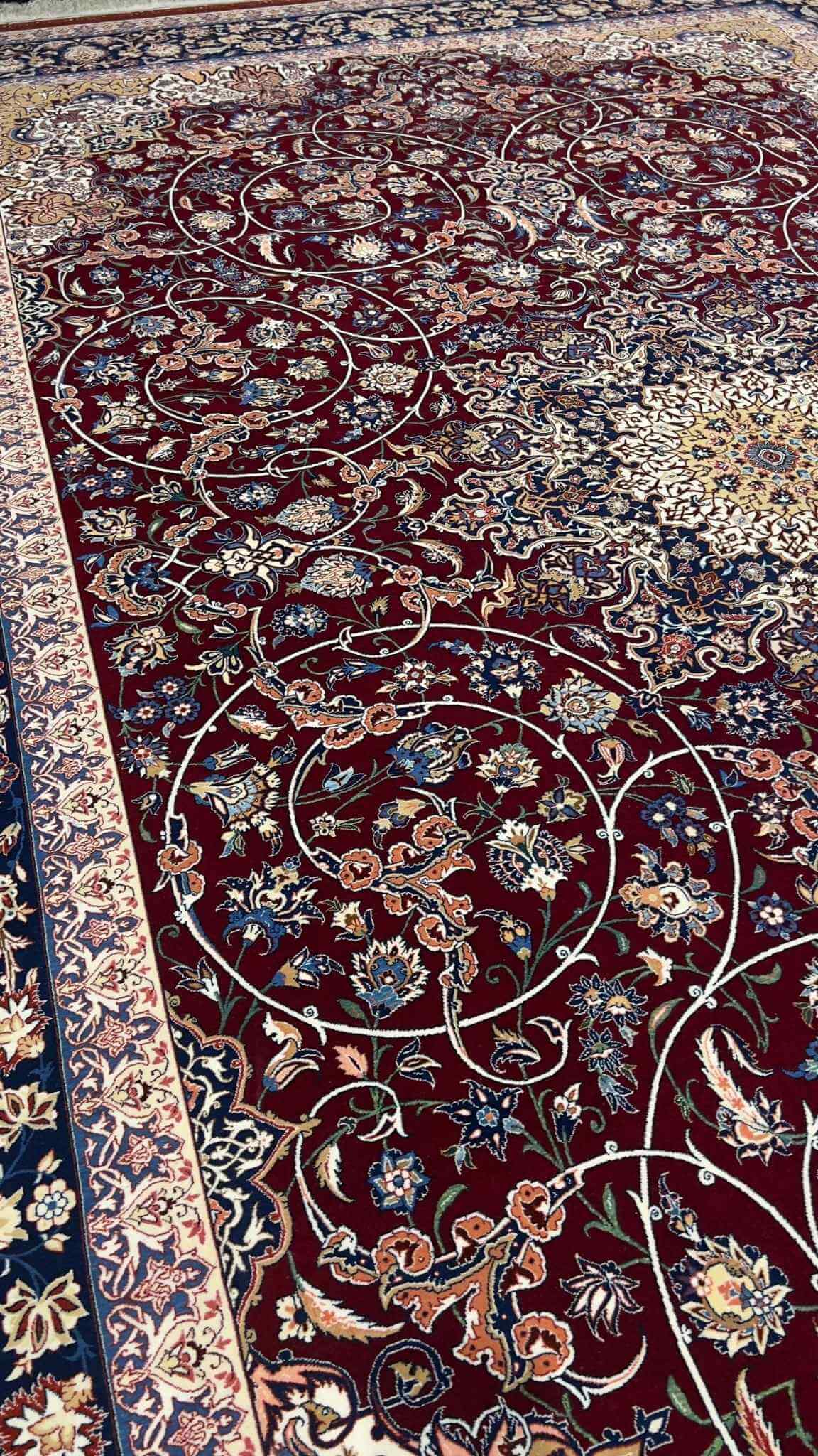 "Luxurious Persian rug featuring a burgundy field and floral motifs with navy and gold accents."